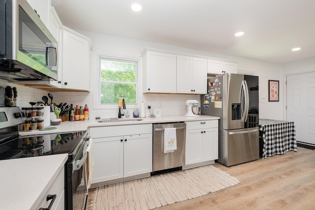106 Aaron Dr, Burns, TN 37029 - kitchen featuring appliances with stainless steel finishes, a sink, decorative backsplash, light countertops, and recessed lighting