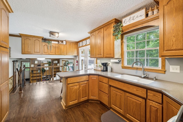 345 Big Spring Hollow Rd, Pulaski, TN 38478 - kitchen featuring a sink, dark wood-style floors, a peninsula, brown cabinets, and a textured ceiling