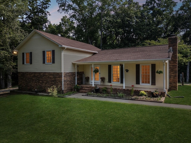 345 Big Spring Hollow Rd, Pulaski, TN 38478 - tri-level home with a porch, a chimney, a front lawn, brick siding, and a shingled roof
