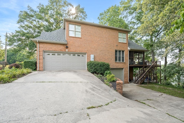 208 Loop Dr, Winchester, TN 37398 - view of side of home with a sunroom, concrete driveway, stairs, roof with shingles, and brick siding