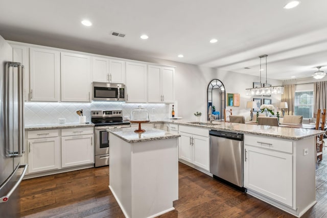 2037 Flowing Creek Dr, Franklin, TN 37064 - kitchen featuring stainless steel appliances, a peninsula, decorative backsplash, white cabinets, and recessed lighting