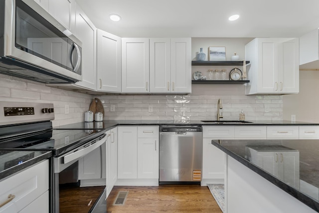 209 Franklin Park, Winchester, TN 37398 - kitchen featuring appliances with stainless steel finishes, open shelves, dark stone counters, white cabinetry, and recessed lighting