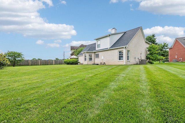 3065 Sakari Cir, Spring Hill, TN 37174 - rear view of house featuring a chimney, central air condition unit, brick siding, a lawn, and roof with shingles