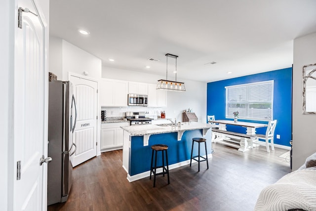 8024 Craighead Dr, Lebanon, TN 37087 - kitchen with appliances with stainless steel finishes, a kitchen breakfast bar, white cabinetry, light stone counters, and tasteful backsplash