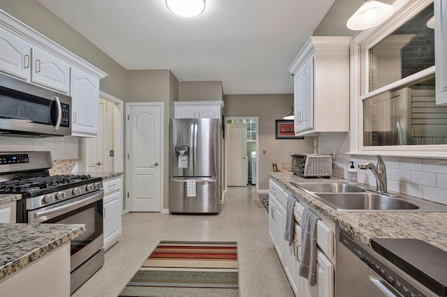 317 Ketch Cv, Hermitage, TN 37076 - kitchen featuring appliances with stainless steel finishes, a sink, white cabinetry, and tasteful backsplash