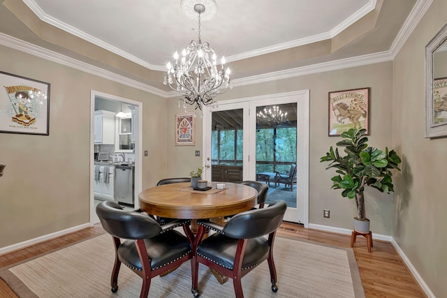 317 Ketch Cv, Hermitage, TN 37076 - dining area featuring light wood-style flooring, a chandelier, a raised ceiling, baseboards, and ornamental molding