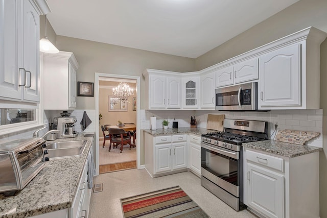 317 Ketch Cv, Hermitage, TN 37076 - kitchen featuring appliances with stainless steel finishes, a sink, a chandelier, and decorative backsplash