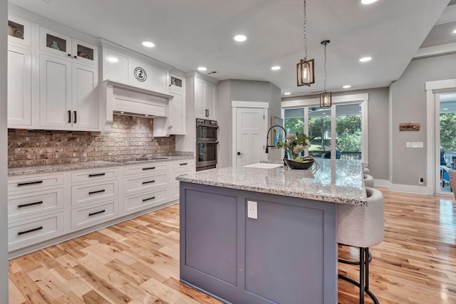 2670 Morgan Rd, Joelton, TN 37080 - kitchen featuring double oven, black electric cooktop, a sink, backsplash, and white cabinets