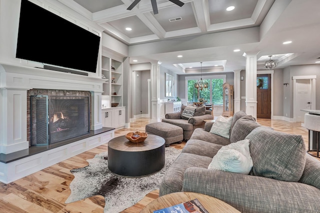2670 Morgan Rd, Joelton, TN 37080 - living area featuring decorative columns, a chandelier, light wood finished floors, a brick fireplace, and built in shelves