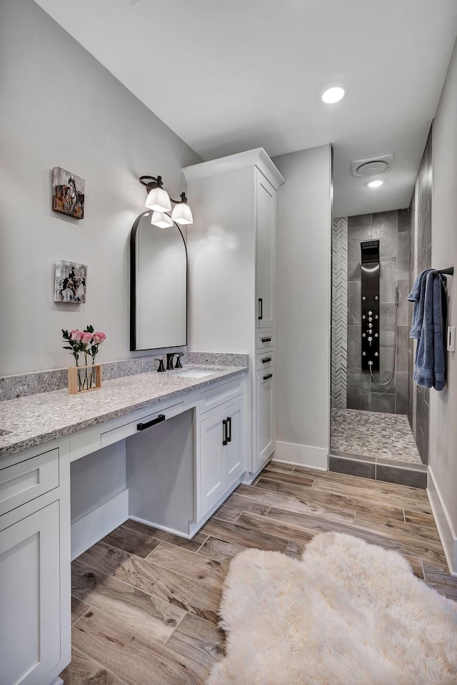 2670 Morgan Rd, Joelton, TN 37080 - bathroom featuring tiled shower, vanity, wood finished floors, baseboards, and recessed lighting