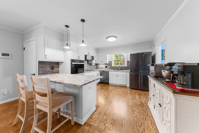 916 Lion Pkwy, Columbia, TN 38401 - kitchen with black appliances, a peninsula, light wood-style floors, white cabinets, and backsplash