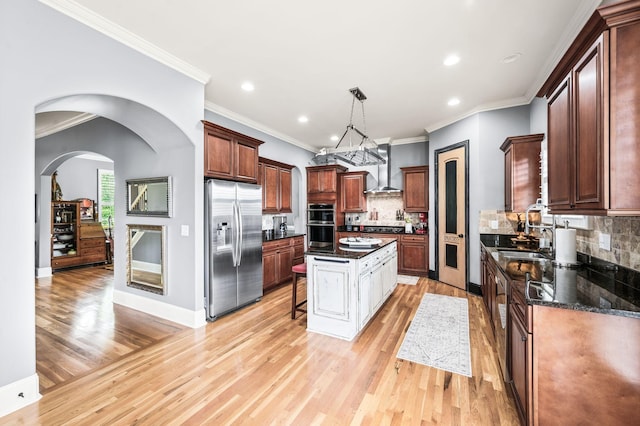 3009 Burnley Ct, Spring Hill, TN 37174 - kitchen with appliances with stainless steel finishes, a sink, wall chimney exhaust hood, light wood finished floors, and a kitchen island