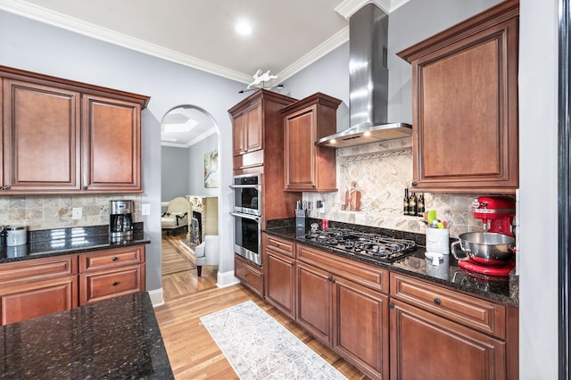 3009 Burnley Ct, Spring Hill, TN 37174 - kitchen with wall chimney exhaust hood, stainless steel double oven, black gas cooktop, crown molding, and light wood-type flooring
