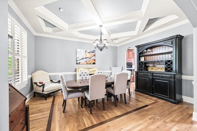 3009 Burnley Ct, Spring Hill, TN 37174 - dining room featuring a chandelier, arched walkways, light wood-style floors, coffered ceiling, and crown molding