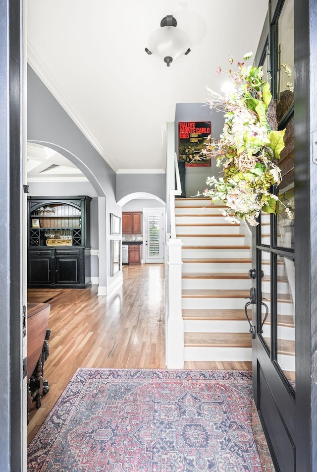 3009 Burnley Ct, Spring Hill, TN 37174 - entrance foyer with arched walkways, wood finished floors, crown molding, stairs, and baseboards