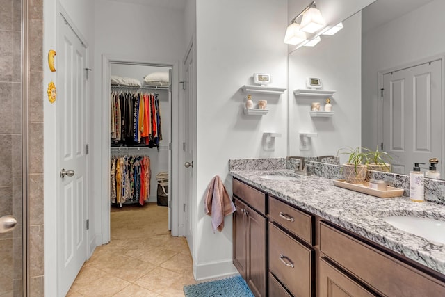 1144 Frewin St, Nolensville, TN 37135 - bathroom featuring double vanity, tile patterned floors, a walk in closet, baseboards, and tiled shower