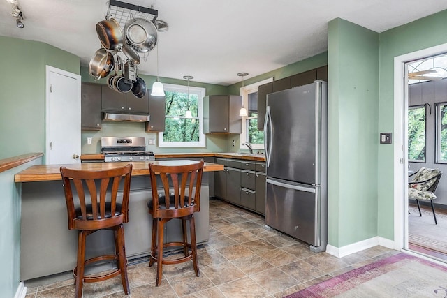 192 Askin Ln, Baxter, TN 38544 - kitchen with appliances with stainless steel finishes, under cabinet range hood, a sink, hanging light fixtures, and butcher block countertops