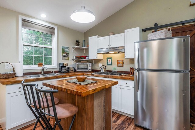 192 Askin Ln, Baxter, TN 38544 - kitchen with wooden counters, appliances with stainless steel finishes, a sink, under cabinet range hood, and white cabinets