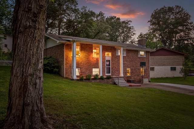 1310 Tabitha Dr, Hixson, TN 37343 - split foyer home featuring a chimney, brick siding, a front lawn, and driveway