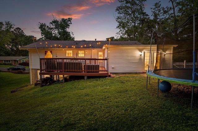 1310 Tabitha Dr, Hixson, TN 37343 - back of house featuring a trampoline, a deck, and a yard