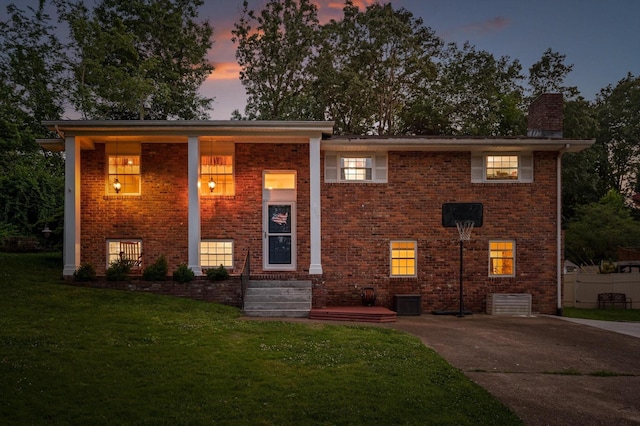 1310 Tabitha Dr, Hixson, TN 37343 - split foyer home featuring a lawn, brick siding, a chimney, and driveway