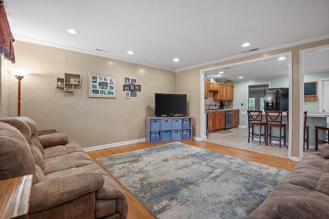1310 Tabitha Dr, Hixson, TN 37343 - living area featuring light wood finished floors, recessed lighting, ornamental molding, and baseboards