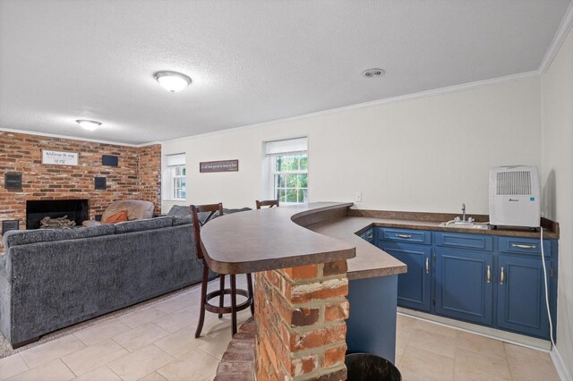 1310 Tabitha Dr, Hixson, TN 37343 - kitchen with blue cabinetry, a sink, a peninsula, a fireplace, and a kitchen bar