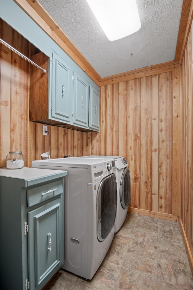 1310 Tabitha Dr, Hixson, TN 37343 - laundry area featuring cabinet space, washer and dryer, wood walls, a textured ceiling, and stone finish floors