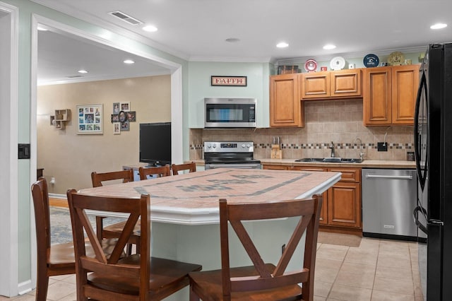 1310 Tabitha Dr, Hixson, TN 37343 - kitchen featuring appliances with stainless steel finishes, a sink, light tile patterned floors, ornamental molding, and tasteful backsplash