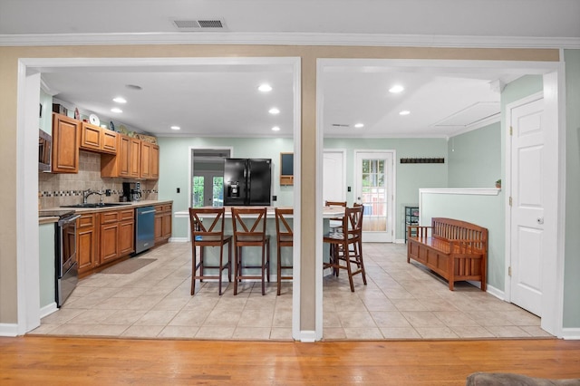 1310 Tabitha Dr, Hixson, TN 37343 - kitchen featuring stainless steel appliances, a sink, light tile patterned flooring, decorative backsplash, and crown molding