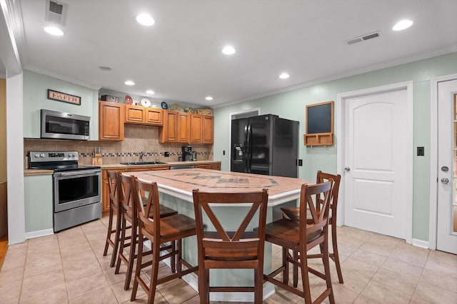 1310 Tabitha Dr, Hixson, TN 37343 - kitchen with stainless steel appliances, ornamental molding, a sink, backsplash, and light countertops