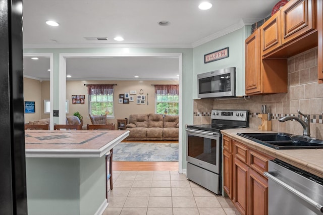 1310 Tabitha Dr, Hixson, TN 37343 - kitchen featuring stainless steel appliances, a sink, tile counters, light tile patterned floors, and decorative backsplash