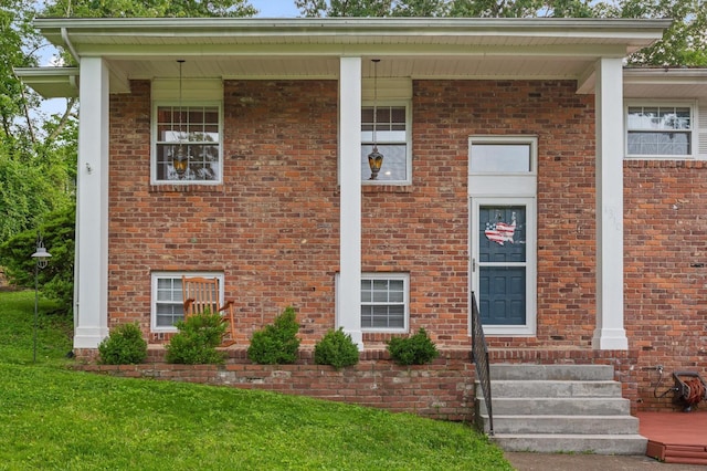 1310 Tabitha Dr, Hixson, TN 37343 - view of exterior entry with brick siding, a yard, and covered porch