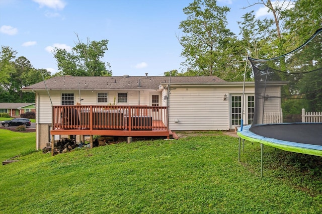 1310 Tabitha Dr, Hixson, TN 37343 - back of property with a trampoline, a wooden deck, a yard, and french doors