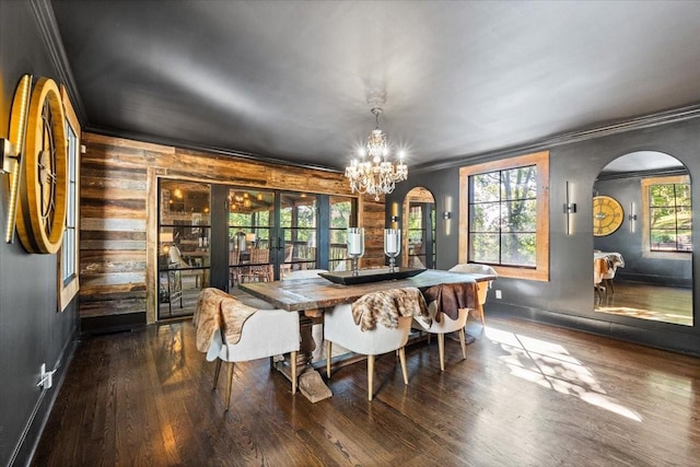 5400 Hillsboro Pike, Nashville, TN 37215 - dining space featuring arched walkways, crown molding, wood finished floors, a chandelier, and wood walls