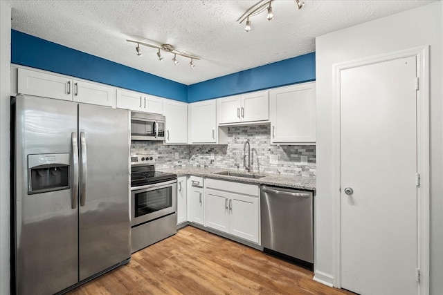 250 Sanders Ferry Rd Unit 65, Hendersonville, TN 37075 - kitchen featuring stainless steel appliances, a sink, white cabinetry, tasteful backsplash, and a textured ceiling