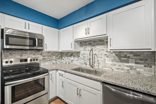 250 Sanders Ferry Rd Unit 65, Hendersonville, TN 37075 - kitchen with stainless steel appliances, a sink, white cabinetry, a textured ceiling, and decorative backsplash