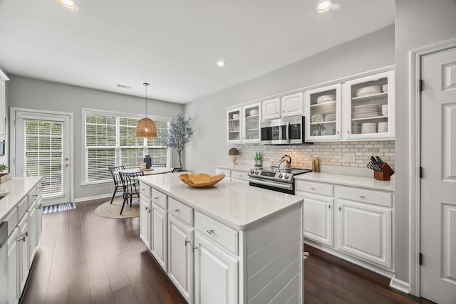 5517 Nevil Pt, Brentwood, TN 37027 - kitchen with appliances with stainless steel finishes, backsplash, a kitchen island, white cabinetry, and glass insert cabinets