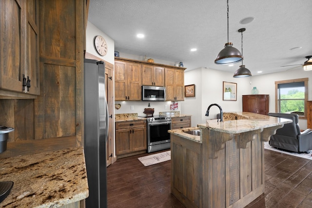 4499 Benson Rd, Springfield, TN 37172 - kitchen with appliances with stainless steel finishes, a sink, dark wood finished floors, a kitchen breakfast bar, and light stone counters