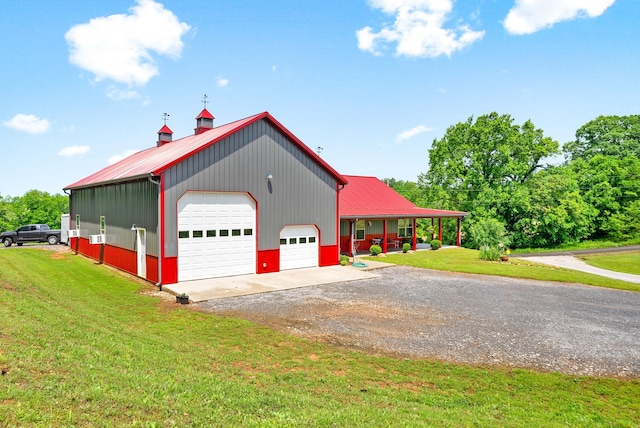 4499 Benson Rd, Springfield, TN 37172 - view of side of home featuring driveway, a lawn, metal roof, a detached garage, and covered porch