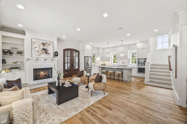 2107 Kidd Rd, Nolensville, TN 37135 - living area featuring a brick fireplace, light wood-style floors, ornamental molding, recessed lighting, and stairs
