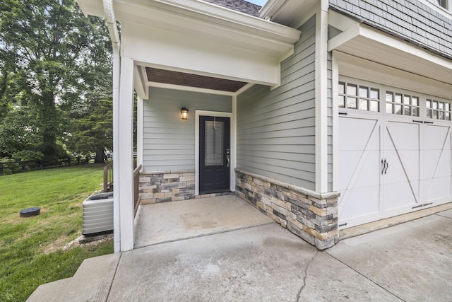 2107 Kidd Rd, Nolensville, TN 37135 - view of exterior entry featuring a yard, stone siding, central AC, and an attached garage
