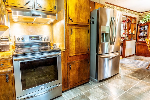 406 Longview St, Camden, TN 38320 - kitchen featuring appliances with stainless steel finishes, under cabinet range hood, brown cabinets, and light countertops