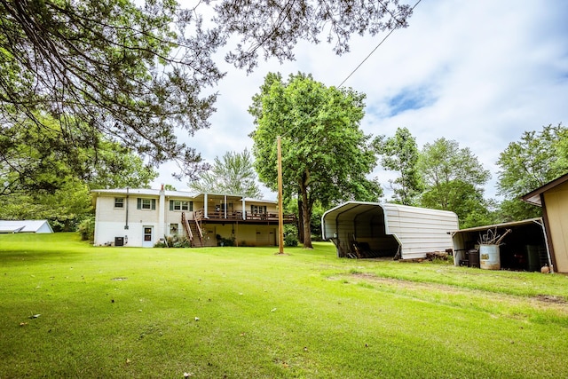 406 Longview St, Camden, TN 38320 - view of grassy yard with stairs, a detached carport, and a wooden deck