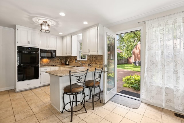 5720 Saint Charles Ct, Hermitage, TN 37076 - kitchen with black appliances, a peninsula, white cabinets, decorative backsplash, and plenty of natural light