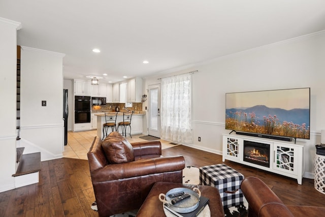 5720 Saint Charles Ct, Hermitage, TN 37076 - living area featuring light wood finished floors, ornamental molding, recessed lighting, baseboards, and a glass covered fireplace