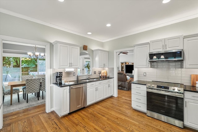 440 Ridgestone Dr, Franklin, TN 37064 - kitchen featuring stainless steel appliances, decorative backsplash, recessed lighting, light wood-style flooring, and a chandelier