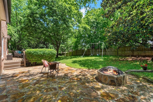 440 Ridgestone Dr, Franklin, TN 37064 - fenced backyard featuring a fire pit, a wooden deck, a patio area, and a playground