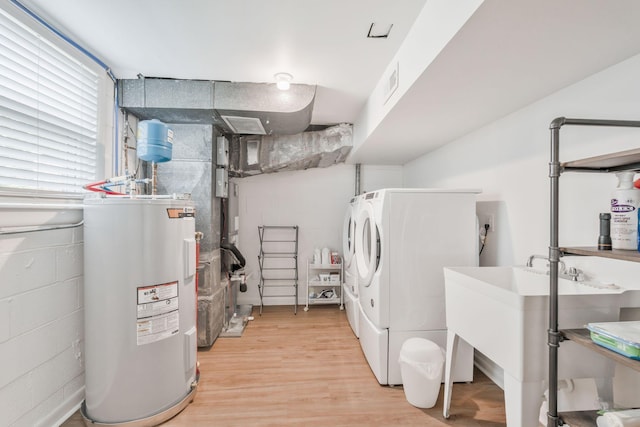 933 Percy Warner Blvd, Nashville, TN 37205 - laundry room with water heater, washer and clothes dryer, concrete block wall, and light wood-style flooring