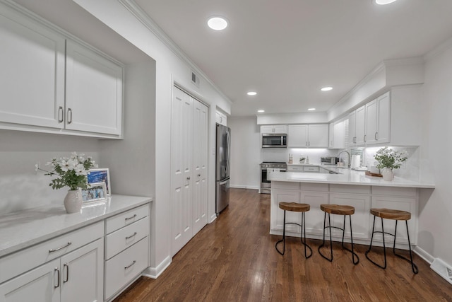 933 Percy Warner Blvd, Nashville, TN 37205 - kitchen featuring appliances with stainless steel finishes, white cabinetry, a peninsula, baseboards, and dark wood-style flooring